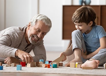 Smiling grandfather playing with young grandson symbolizing Grandparents And Custody