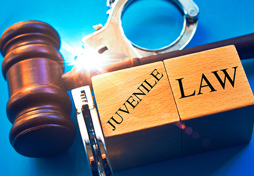 Gavel, pencil, and a notebook with JUVENILE LAW written on the cover.