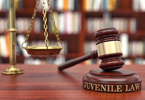 Gavel and Scales of Justice on a law book shelf.