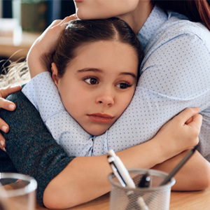 A close-up of a child receiving a comforting hug during a difficult time.