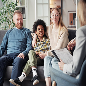 A family sitting on a couch during a legal consultation with a professional advisor.